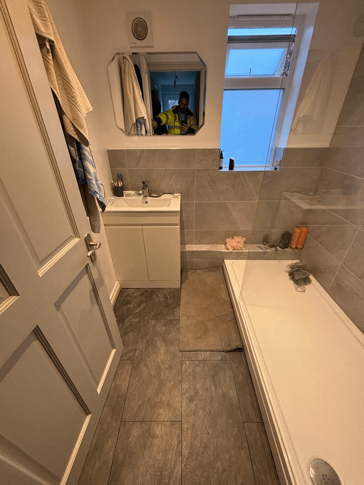 Completed bathroom — grey large-format tiles with new vanity unit and bath