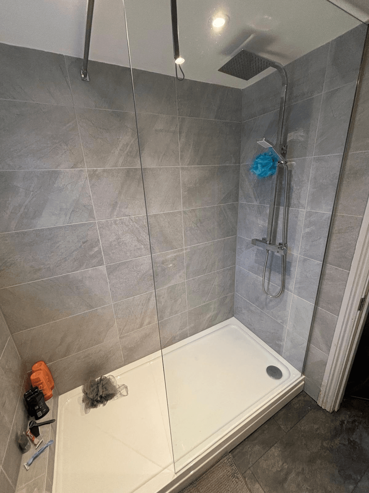 Completed walk-in shower — grey stone tiles with thermostatic shower