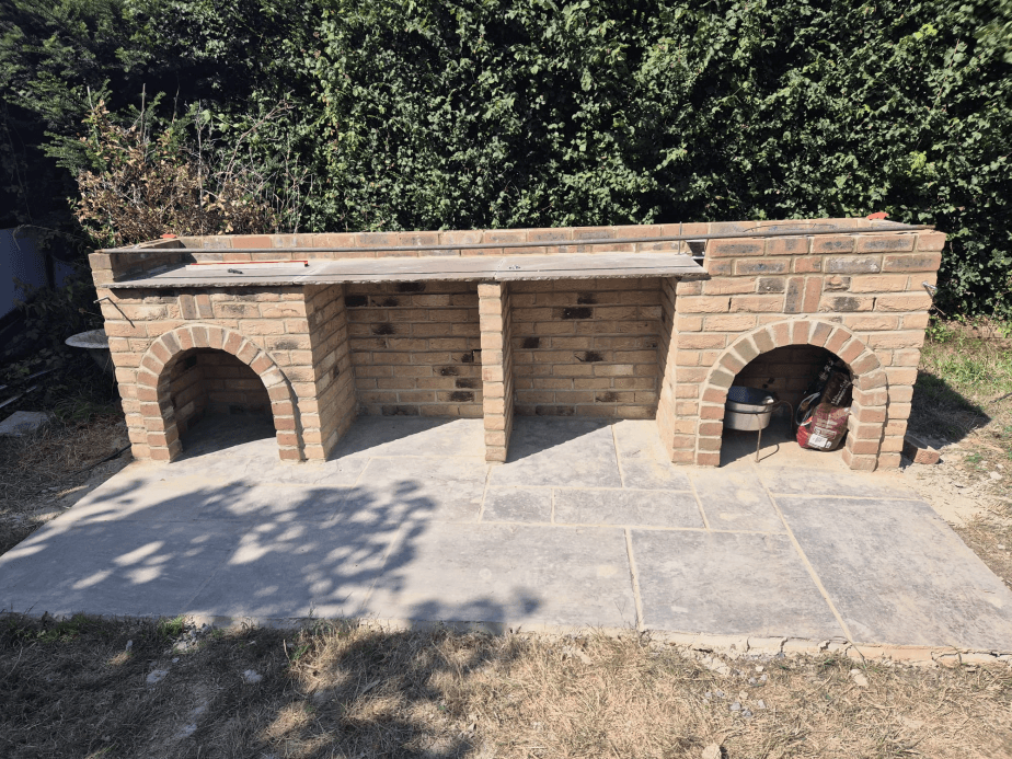 Large outdoor brick BBQ kitchen with arched alcoves