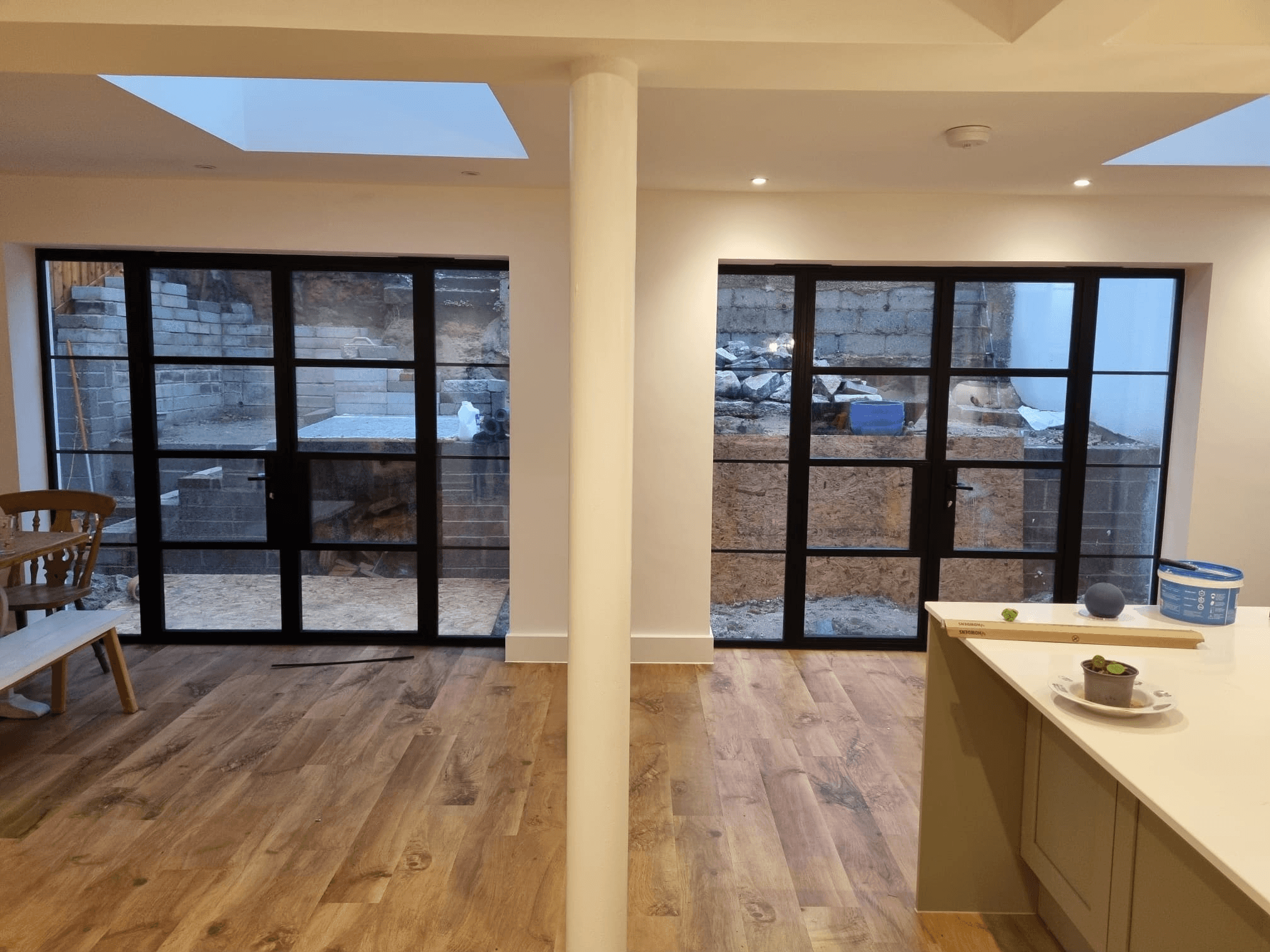 New extension interior with Crittall-style glazed doors — open-plan kitchen and dining