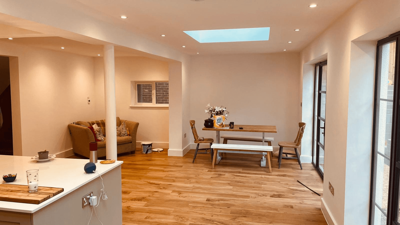 Completed open-plan extension interior with skylight and wood flooring