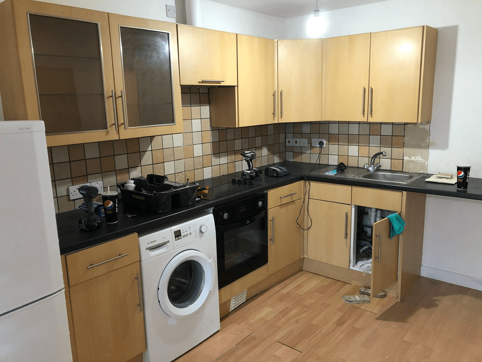 Kitchen before renovation — old units ready for strip-out