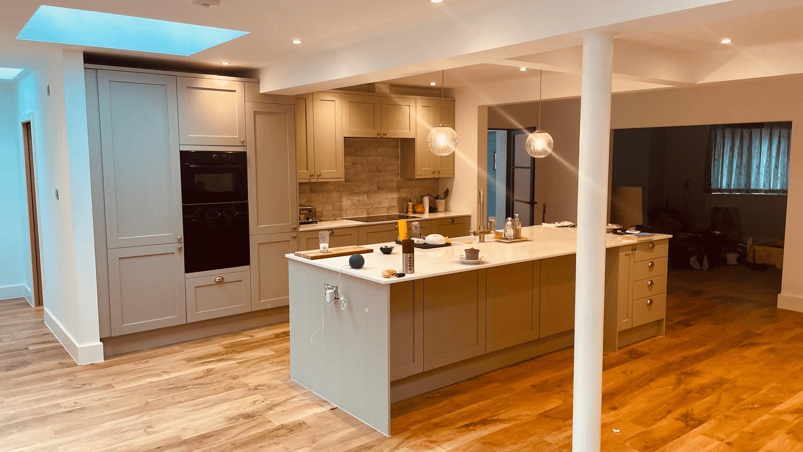 Completed kitchen with large island, skylights and open-plan living space