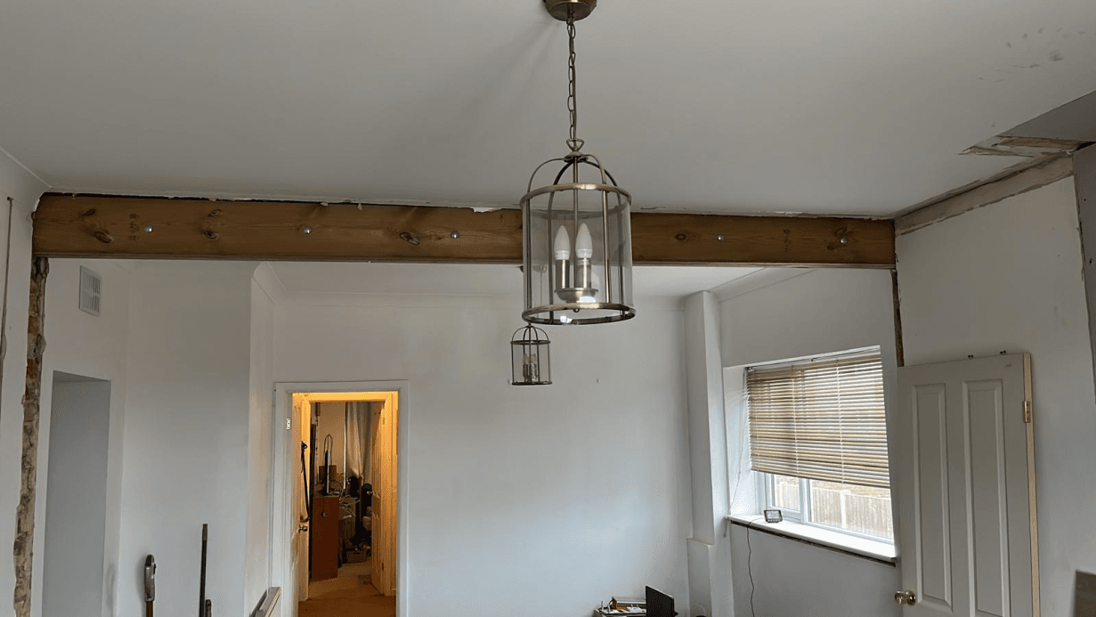 Structural beam exposed after wall removal — new open-plan room