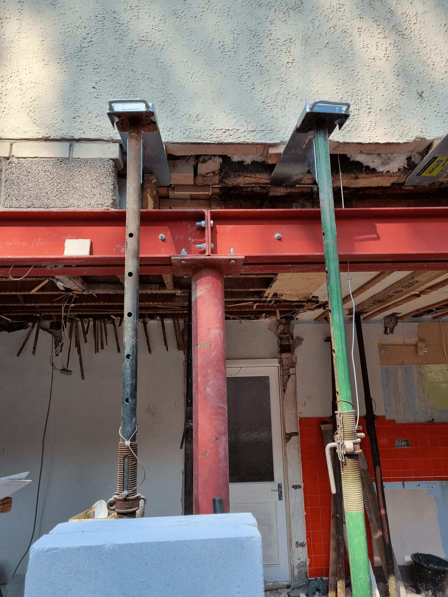 Acrow props and RSJ steel beam supporting load-bearing wall — exterior structural works